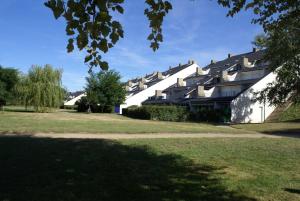 a large white building on a grass field at REF 014 - T2 mezzanine pour quatre personnes Terrasses de Kerjouanno ARZON in Arzon