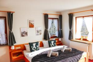 een slaapkamer met een bed en twee ramen bij House of Happiness by apartmentglück in Schluchsee