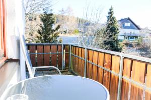 een balkon met een tafel en een stoel aan een hek bij House of Happiness by apartmentglück in Schluchsee