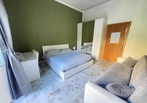 a bedroom with a bed and a couch at Mi casa tu casa - Guest House in Catania