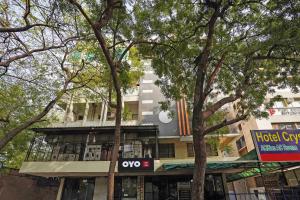 a building on a street with trees in front of it at Hotel O Crystal in Ahmedabad +24 photos