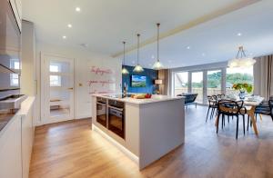 Una cocina y una sala de estar con mesa y sillas. en Art House Seahouses, en Seahouses