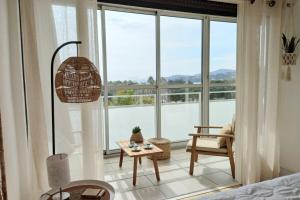 a room with a large window with a table and a chair at T2 vue à 100m de la plage avec parking privé in Bormes-les-Mimosas +5 photos