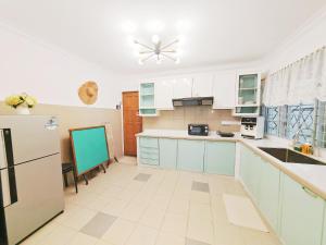 a kitchen with blue cabinets and a refrigerator at HT Homestay BigSemi-D BBQwedding in town in Jelutong