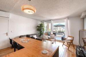 a living room with a table and a dining room at Superb apartment on the port of Favière in Bormes-les-Mimosas +14 photos