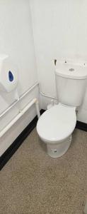a bathroom with a toilet and a roll of toilet paper at Stone Circle Glamping in Durrington