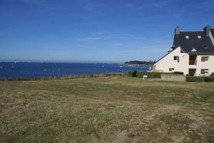 a house in a field next to the water at REF 024 Appartement deux chambres vue mer parc du Fogeo Arzon in Arzon +2 photos