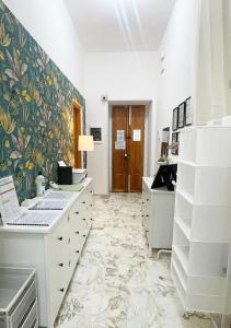 a white bathroom with a flower patterned wall at Mi casa tu casa - Guest House in Catania