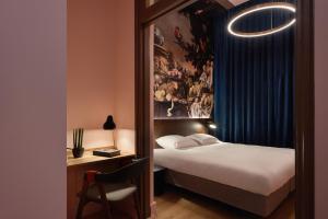 埃因霍温Hotel Mariënhage的酒店客房配有一张床和一张带椅子的书桌