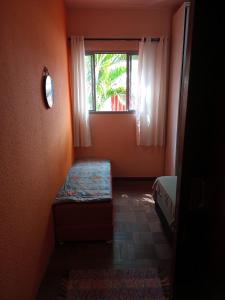 ein kleines Zimmer mit einer Bank und einem Fenster in der Unterkunft Alojamento do João in Lagoa Santa