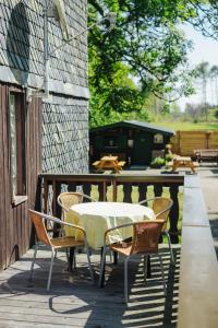 a table and chairs on a wooden deck at Pension und Gastwirtschaft Mareile am Rennsteig in Rodacherbrunn