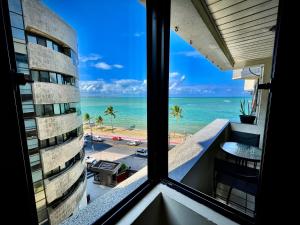 een kamer met een raam met uitzicht op het strand bij BEIRA MAR 2 Quartos com Ar e Cozinha Completa in Maceió