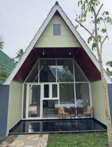 a small house with a large window and a table at Kaliningrat Cottage 2 in Pronojiwo