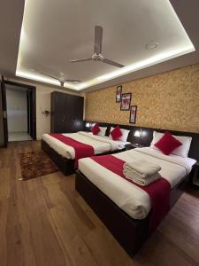 a hotel room with two beds with red pillows at HOTEL DIAMOND AND RESIDENCES - Vijay Nagar INDORE in Indore +19 photos