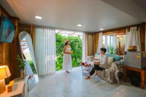a man and a woman standing in a living room at Nj homestay in Ban Thung Phan Ha