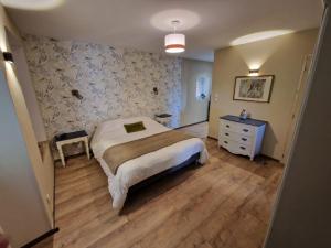 a bedroom with a bed and a dresser in it at La forge des vignes in Menetou-Râtel