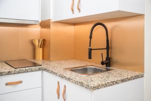 a kitchen counter with a sink and a faucet at Studio Oporto (Gaia) in Vila Nova de Gaia