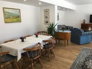 una sala da pranzo con tavolo, sedie e divano di Appartements Caroline a Ossiach