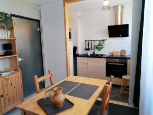a kitchen and dining room with a wooden table and chairs at Appartement centre ville avec parking privatif in Dijon +8 photos