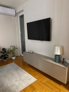 a living room with a flat screen tv on a wall at Urban Apartman-privatan parking- in Kraljevo