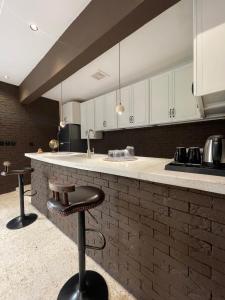 a kitchen with a counter with two bar stools at Cali chalets in Riyadh