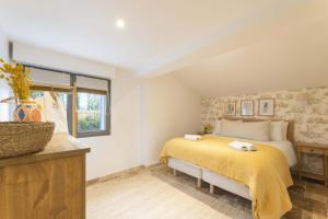 クリックブフにあるMaison Longere Beautiful House near Deauvilleの黄色い毛布が掛けられたベッドのある寝室