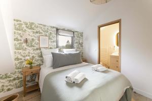 クリックブフにあるMaison Longere Beautiful House near Deauvilleのベッドとタオル2枚のある寝室