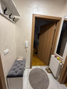 a hallway with a door and a stool in a room at Urban Apartman-privatan parking- in Kraljevo
