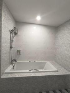 a bath tub in a bathroom with a sink at Private Room 8 in Ban Bua Ngam