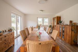 a dining room with a long table and chairs at Haus AchtsamZeit in Hentern