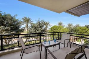 a balcony with chairs and a view of trees at Sunny Cairo City Center l Serviced l Golf l Pool l Gym l 1 in Cairo