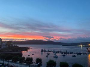 a group of boats in the water at sunset at Besbello in Camariñas