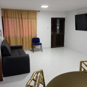 un salon avec un canapé et une télévision dans l'établissement Apartamento al norte de Barranquilla, à Barranquilla