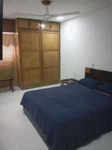 - une chambre avec un lit bleu et un grand placard dans l'établissement Apartamento al norte de Barranquilla, à Barranquilla
