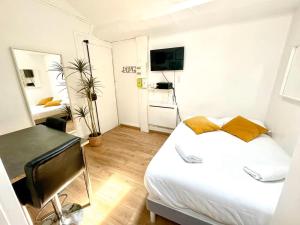 Un dormitorio con una cama, un escritorio y un televisor. en BnGo I Le Douillet I Parc Tete d'Or, 2 personnes, Hypercentre Lyon, en Lyon