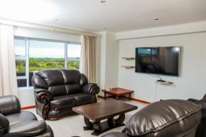 a living room with leather chairs and a flat screen tv at Santareme Seaviews in Sea Vista