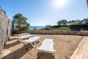 L'Ametlla de MarにあるHauzify I Casa Ginestaの海の横に座る白い椅子