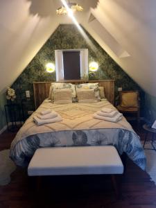 a bedroom with a large bed in a attic at Le Grenier in Goussainville