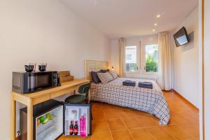 a bedroom with a bed and a microwave in it at Villa Pattos in Santa Coloma de Farners