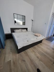 a bedroom with a large bed with a wooden floor at Стаи за гости Пауза in Stara Zagora