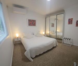 カトゥーンバにあるGreat location - Katoomba Homeの大きな白いベッドと窓のある白い寝室