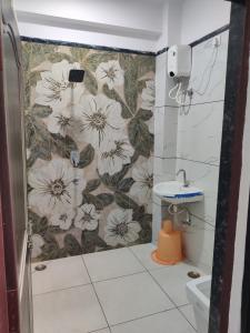 RāipurHotel Anand shree的带淋浴的浴室和花卉壁纸 更多3张照片
