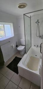 カトゥーンバにあるGreat location - Katoomba Homeの浴槽とトイレのある白いバスルーム +5枚の写真