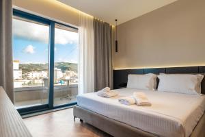 a bedroom with a large bed and a large window at SASSO Hotel in Vlorë