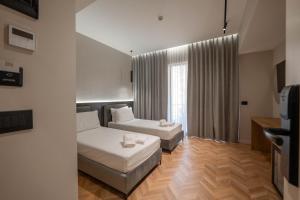 a living room with two beds and a couch at SASSO Hotel in Vlorë