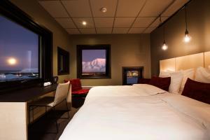 a bedroom with a bed and a desk and a window at Svalbard Hotell | The Vault in Longyearbyen +13 photos