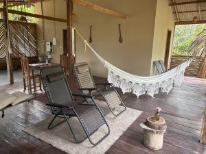 a hammock in a room with chairs and a table at Ponta Poranga Jungle Lodge in Manaus
