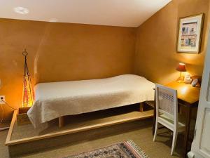 a small bedroom with a bed and a desk at Le Fraysse in Montdurausse