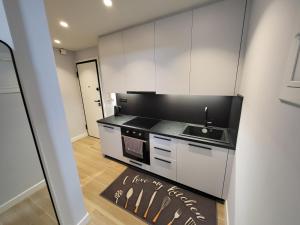 a kitchen with white cabinets and a black counter top at Kolonaki Studio in Athens