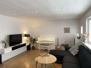 a living room with a couch and a piano at The Northern Escape in Klaksvík